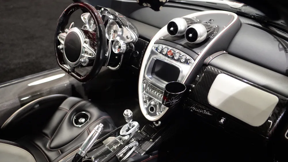 Luxurious car interior with a wood-rimmed steering wheel, chrome gauges, and a glossy center console.