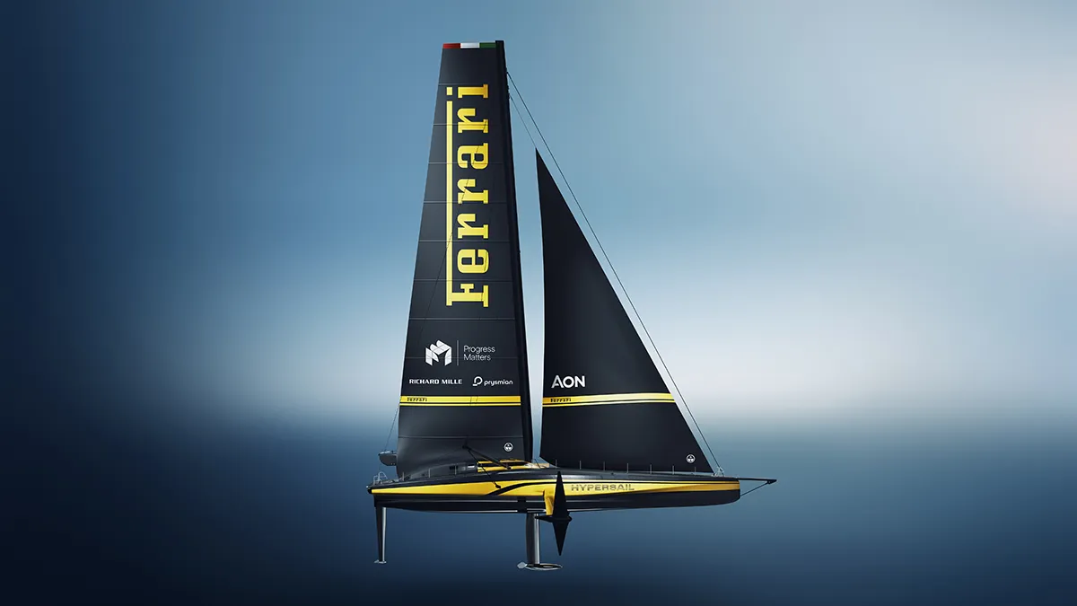 High-speed black-sailed racing catamaran with yellow trim and Ferrari branding gliding over blue water