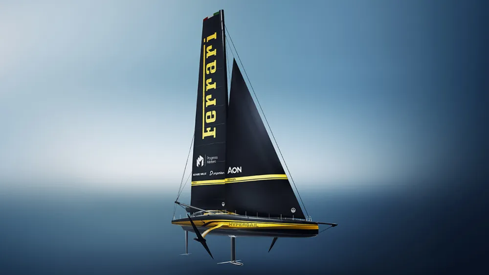 Foiling racing sailboat with a tall black sail marked Ferrari, gliding over blue water.