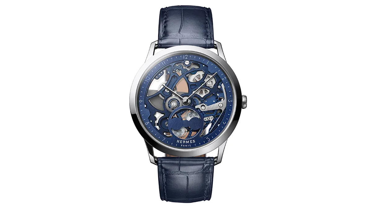 Hermès skeleton wristwatch with a blue dial, visible gears, and a blue leather strap