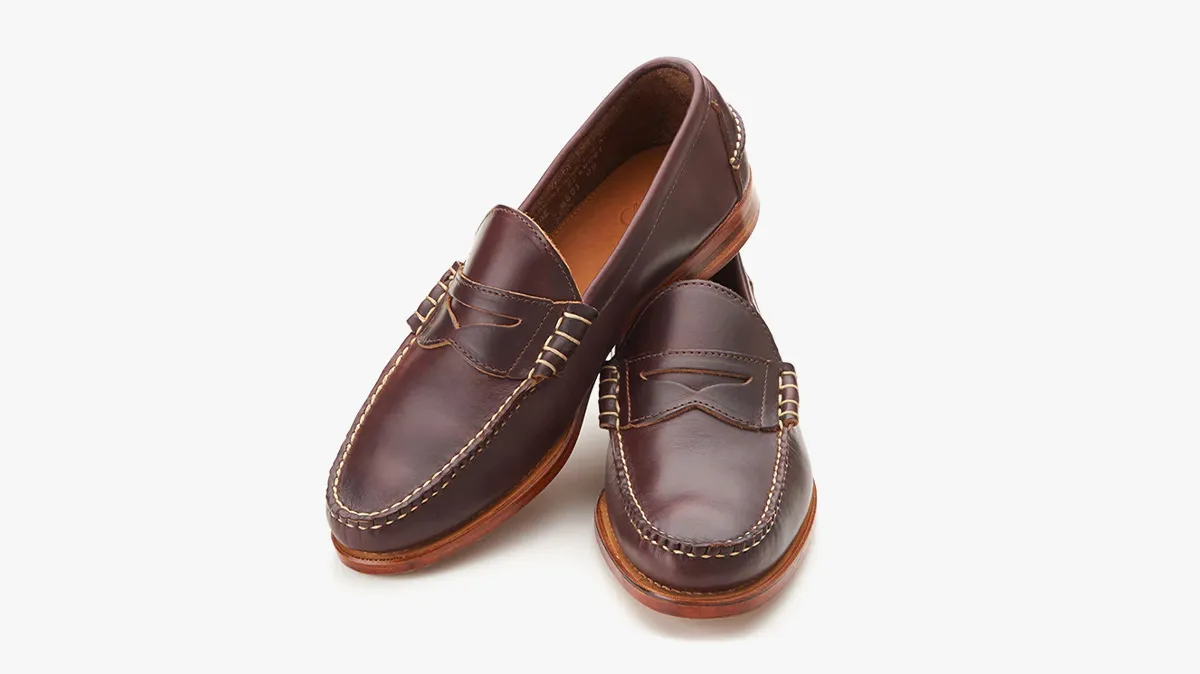 Pair of dark brown leather loafers with tan stitched sole, shown from above/side angle for product detail.