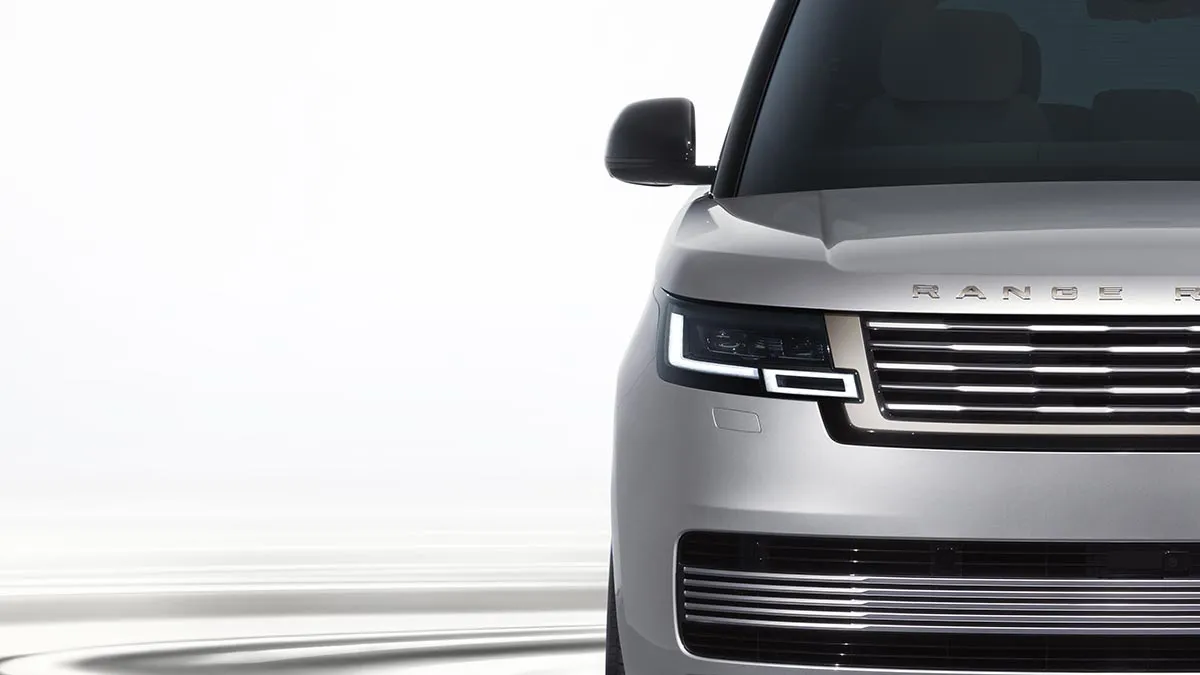 Front view of a silver Range Rover showing the grille and headlight on the right side of the image