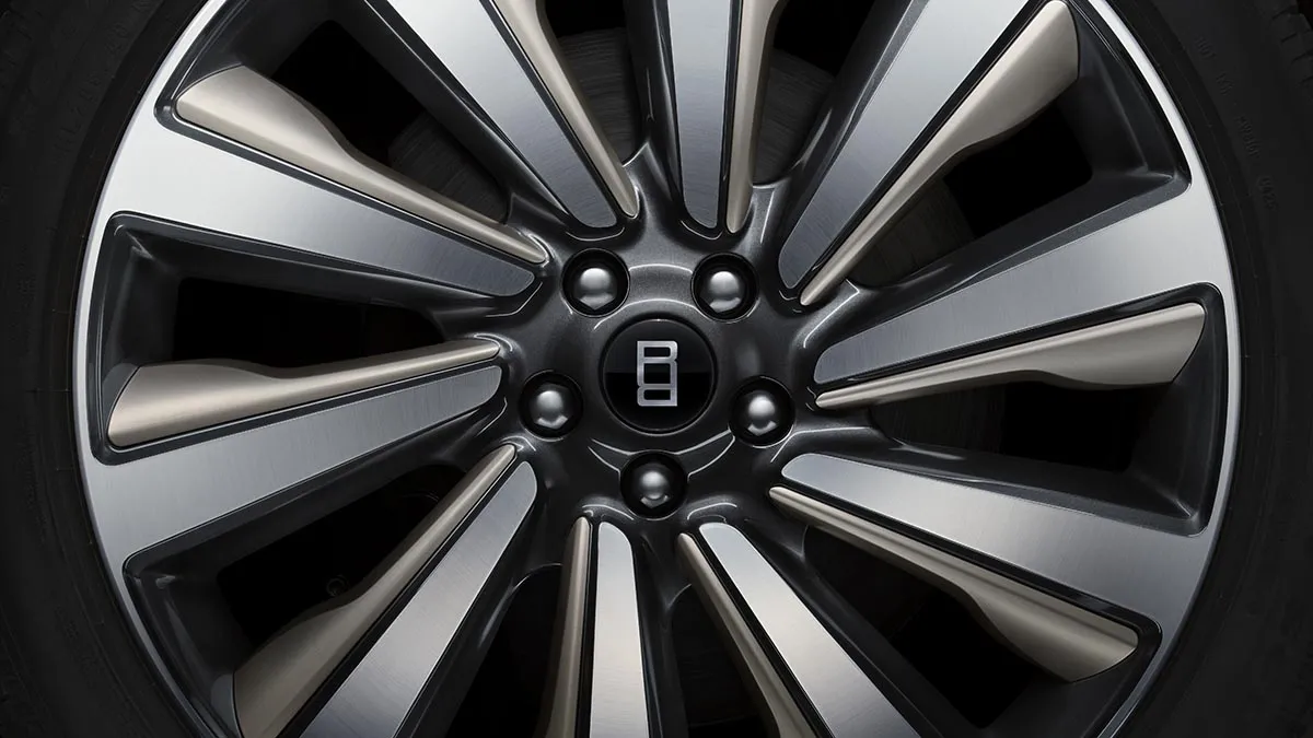 Close-up of a Bentley alloy wheel with a multi-spoke design and central B emblem.