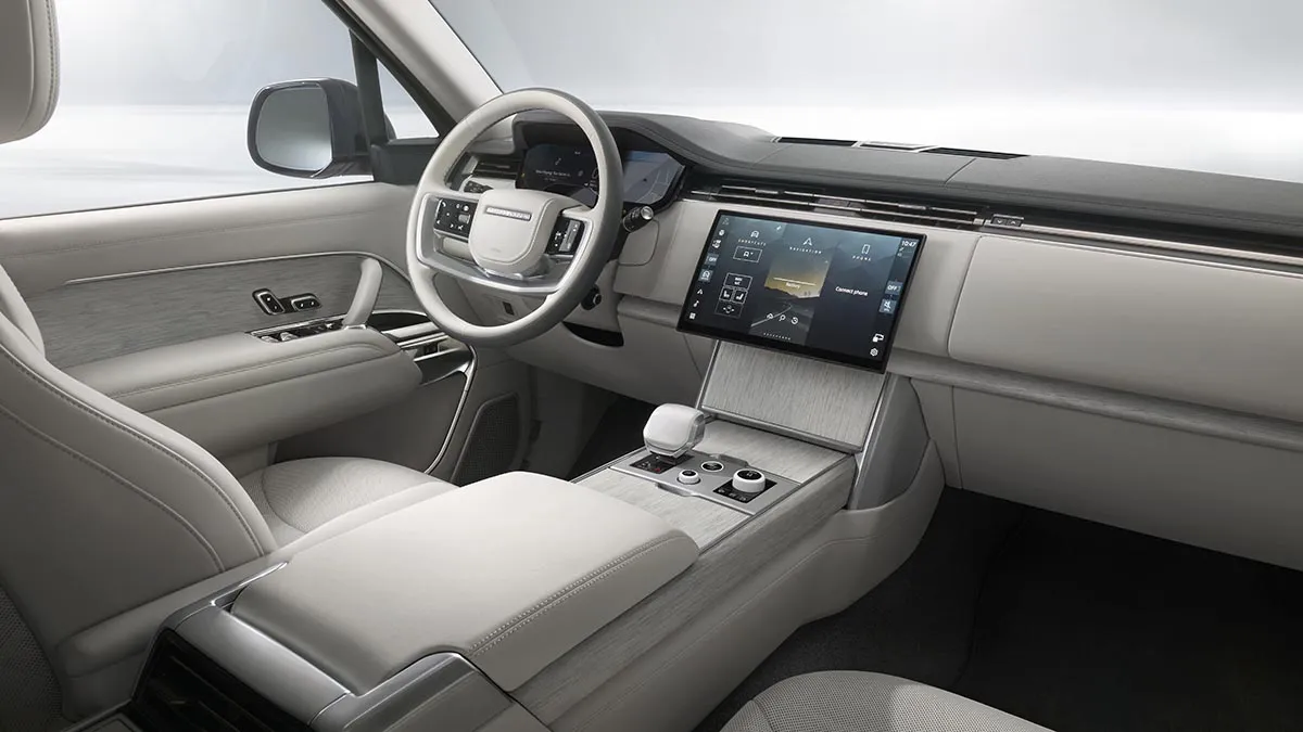 Light gray luxury car interior with a large central touchscreen and sleek console.