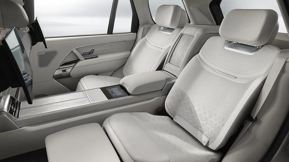 Luxurious car interior with light-gray leather seats and a wide center console between front seats