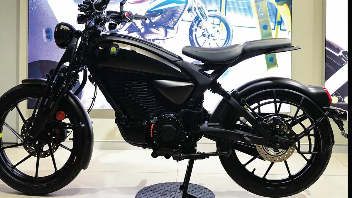 Black motorcycle on a display stand in a showroom, side view.