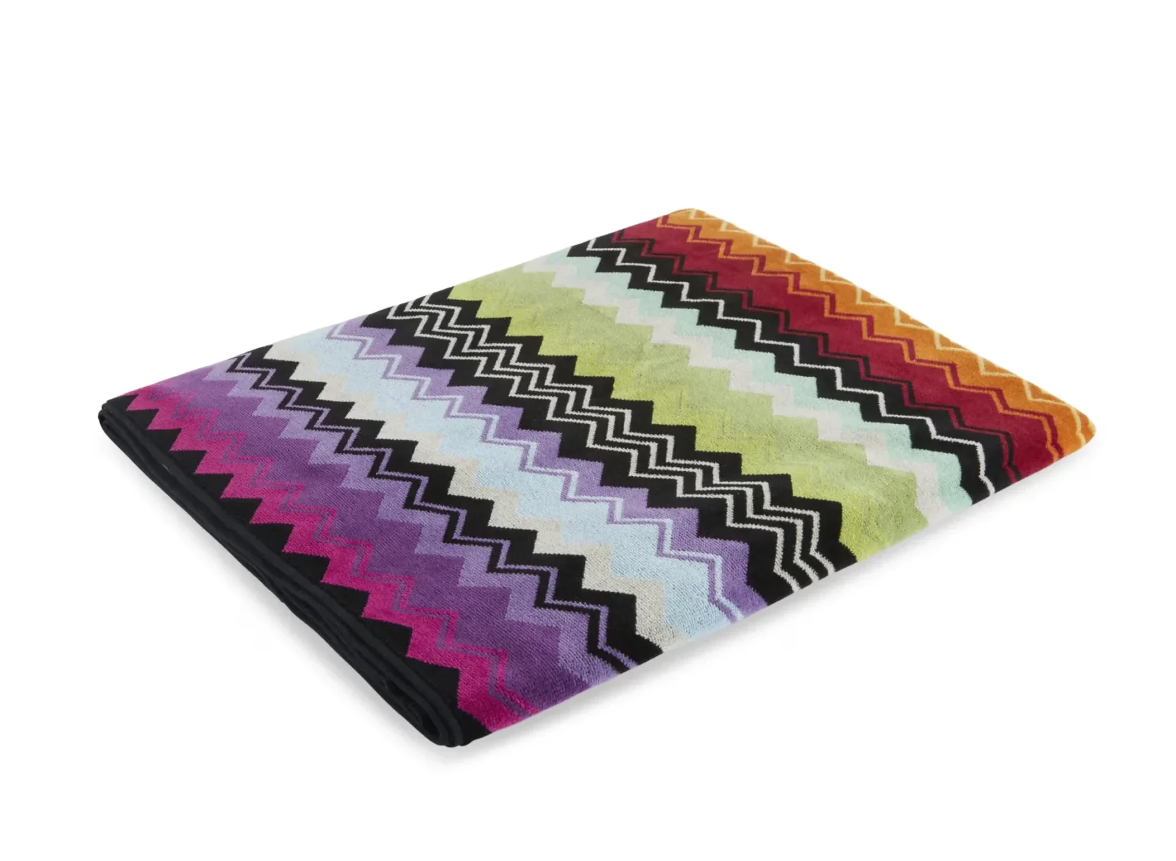 Folded multicolor chevron-pattern blanket with zigzag stripes in rainbow colors.