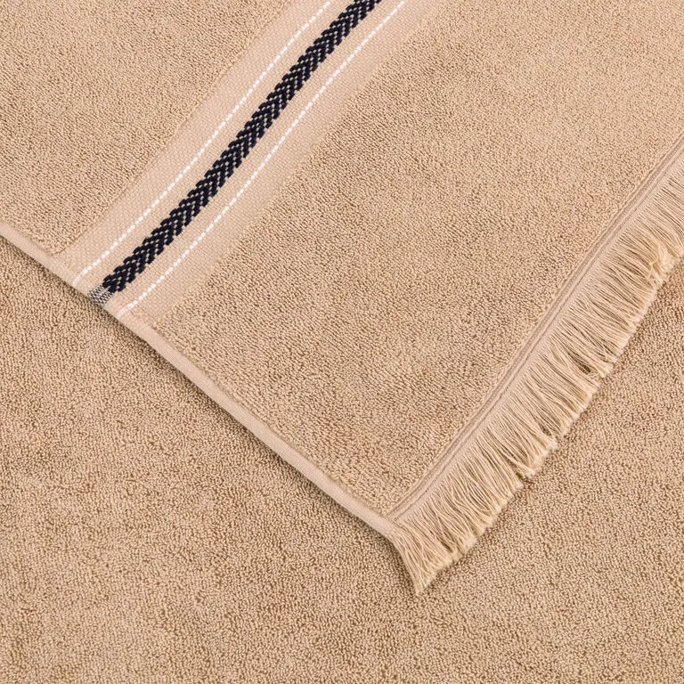 Beige towel with a fringed edge and a dark striped border along one corner.