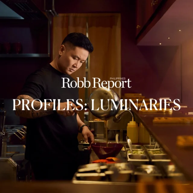 Chef in a dim kitchen pours sauce from a ladle into a pan, with ingredients and equipment visible; bold headline reads 'Robb Report Philippines: Profiles: Luminaries' over the scene.