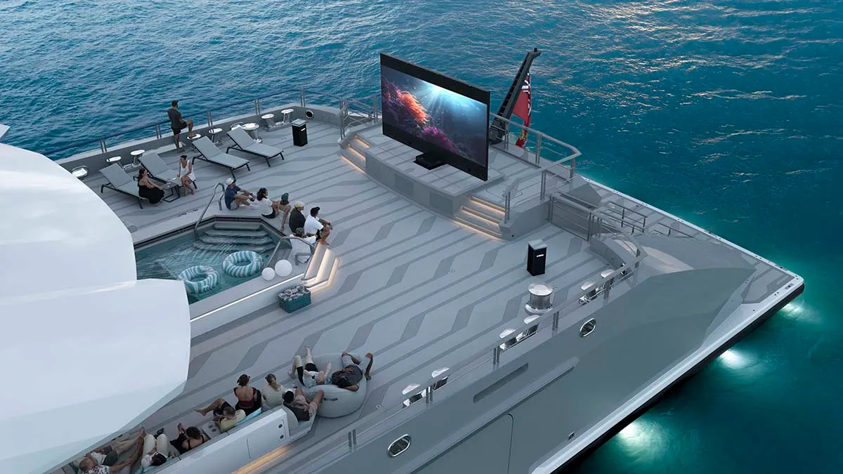Luxurious yacht deck with an outdoor cinema screen, guests lounging on sunbeds and seating around a pool. The ocean is visible in the background.