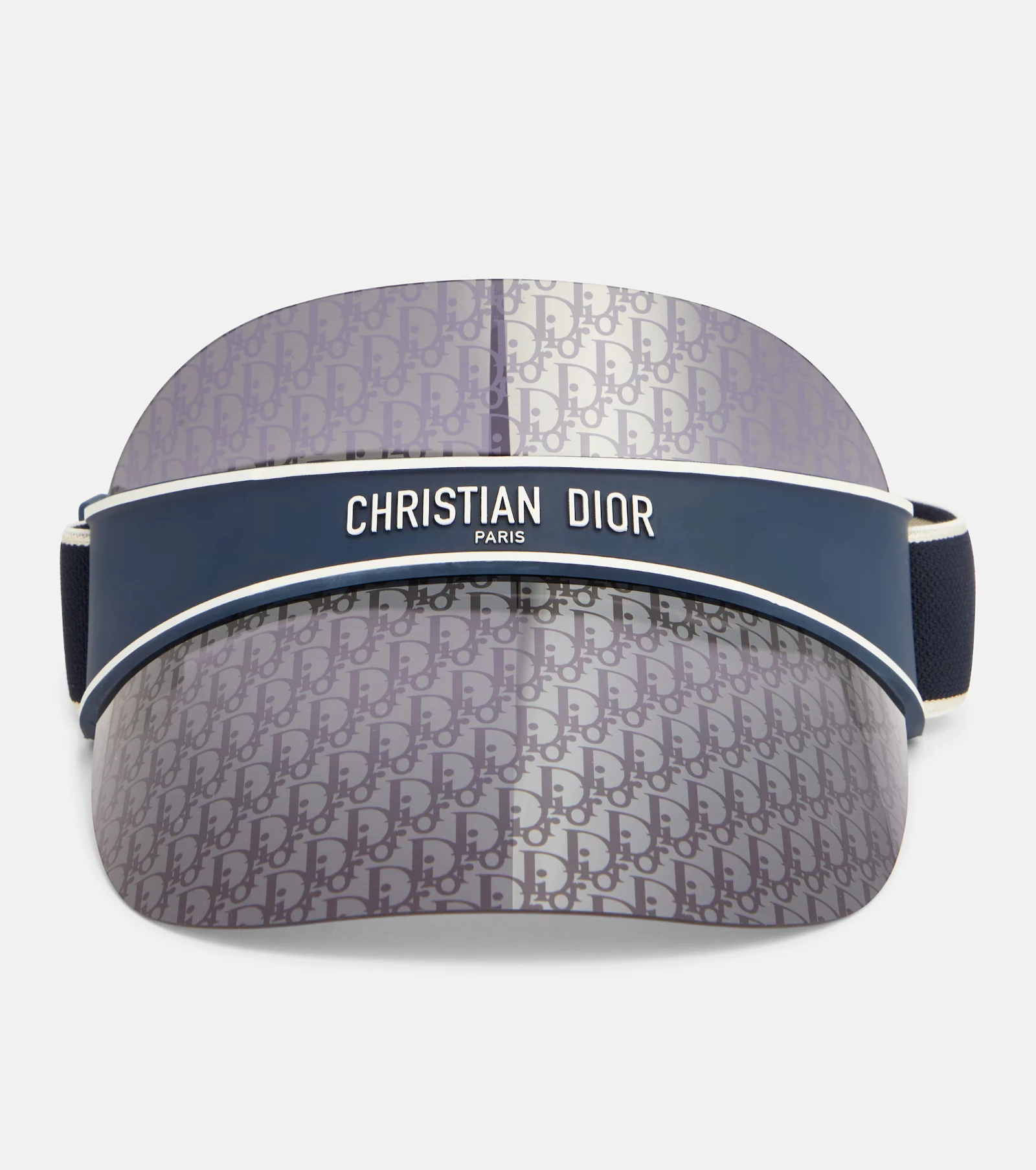 Close-up of a Dior visor with a repeating monogram pattern and a dark blue band reading 'CHRISTIAN DIOR PARIS' across the front.