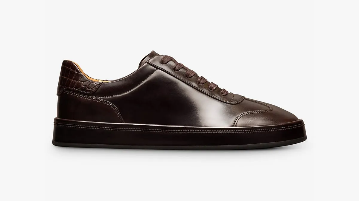 Dark brown leather sneaker with a smooth finish and textured heel, flat sole, and lace-up design for men’s casual wear