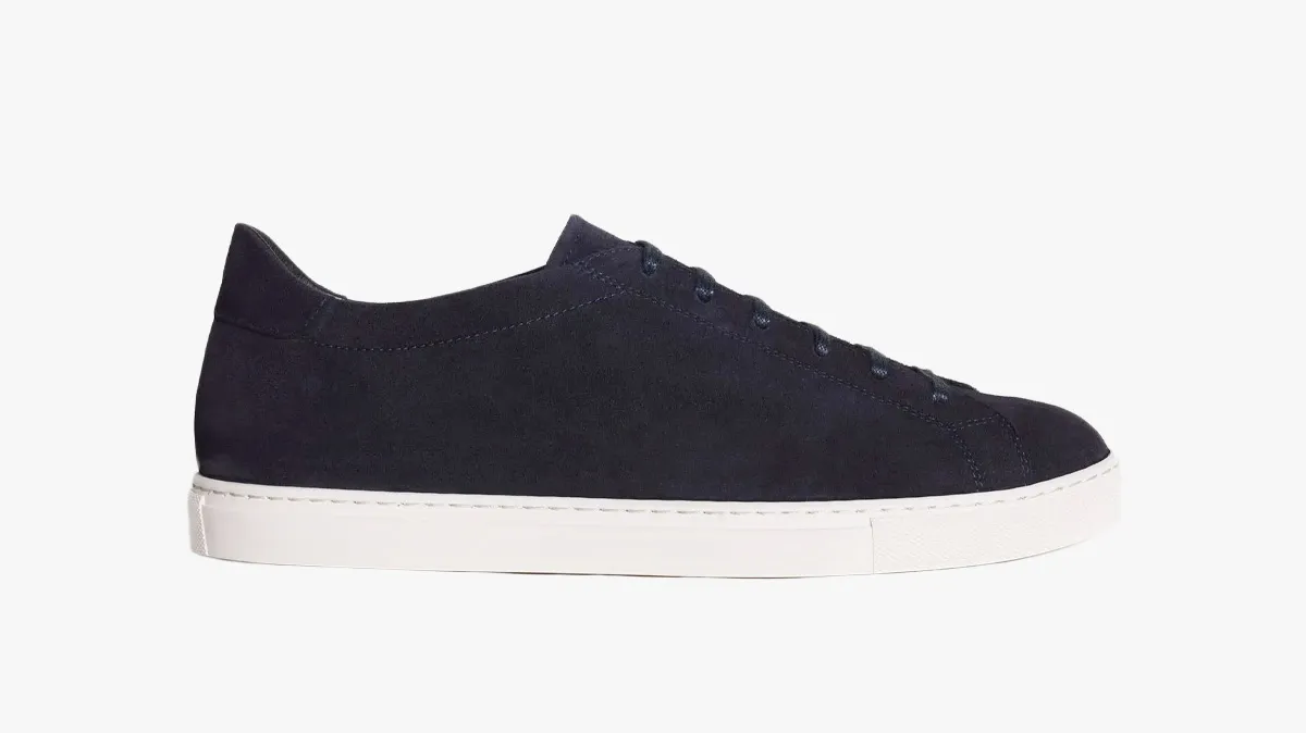 Navy suede low-top sneaker with a white rubber sole, shown in side profile.