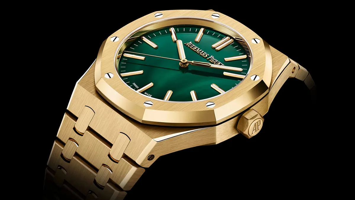 Gold-toned luxury wristwatch with a green dial and octagonal bezel, featuring exposed screws and a linked bracelet (Audemars Piguet).