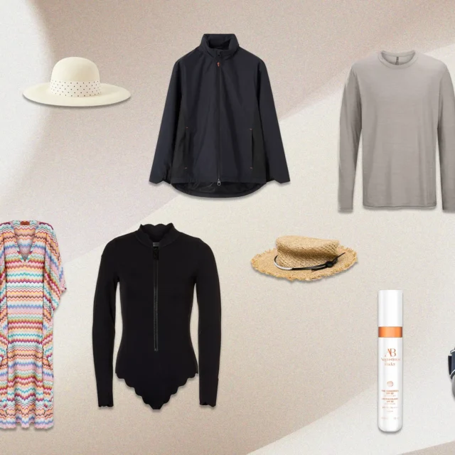 Assorted fashion items arranged on a beige backdrop: blue floral swim shorts, white sun hat, navy lightweight jacket, gray long-sleeve shirt, white tote bag, turquoise notebook, multicolored chevron cardigan, black zip-front cardigan, straw hat, sunscreen spray, and a patterned bucket bag.