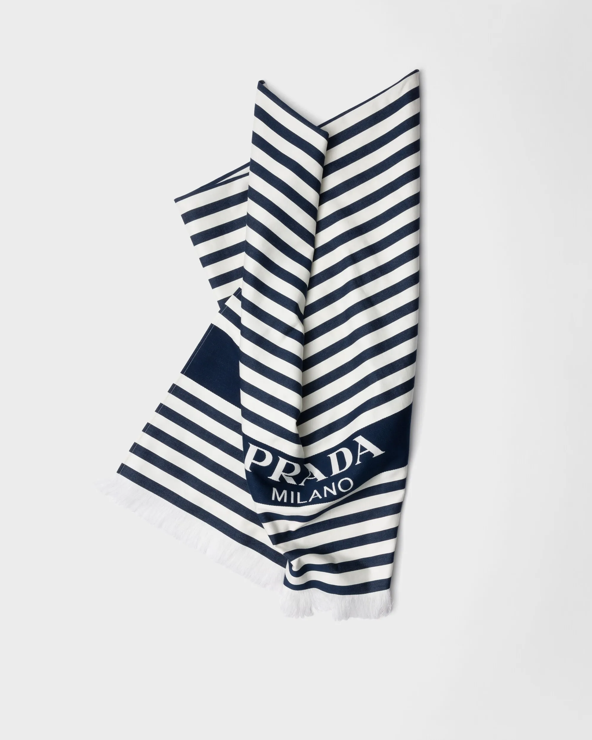 Navy and white striped scarf with fringe at the ends, Prada Milano logo partially visible on the fabric.