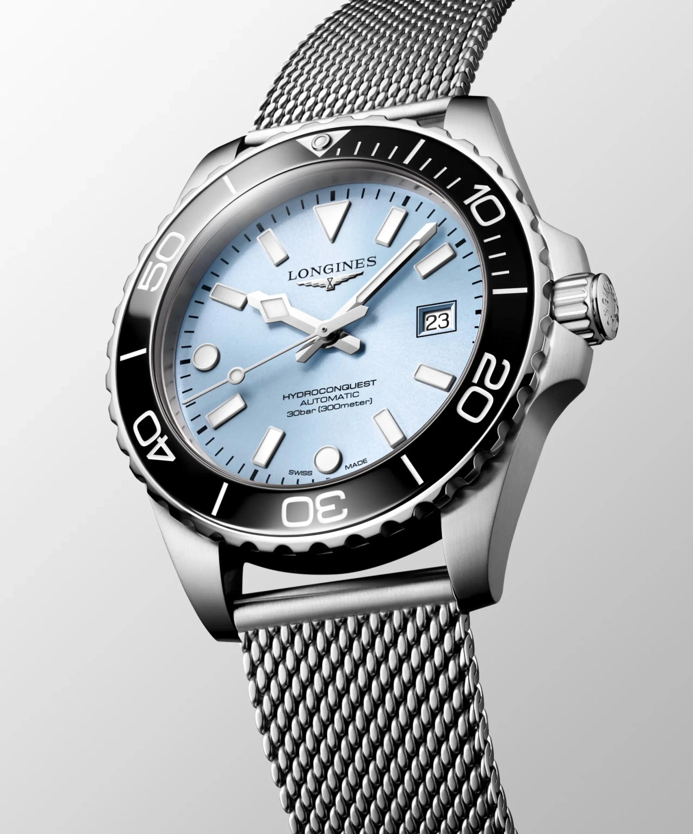Close-up of a Longines HydroConquest watch with a blue dial, black bezel, and a stainless steel mesh bracelet.