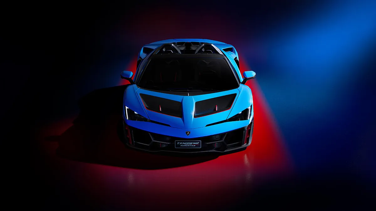 Front view of a blue Lamborghini-style sports car under dramatic red and blue studio lighting.