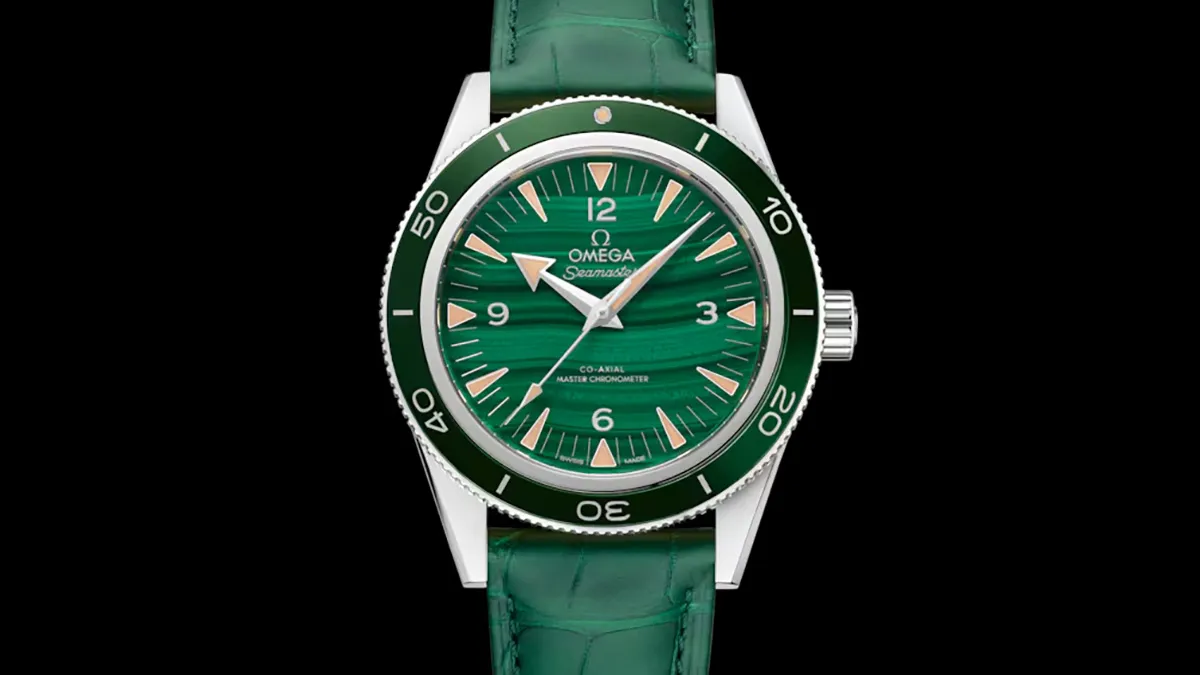 Green dial Omega Seamaster diver's watch with a unidirectional bezel and green strap, shown on a black background.