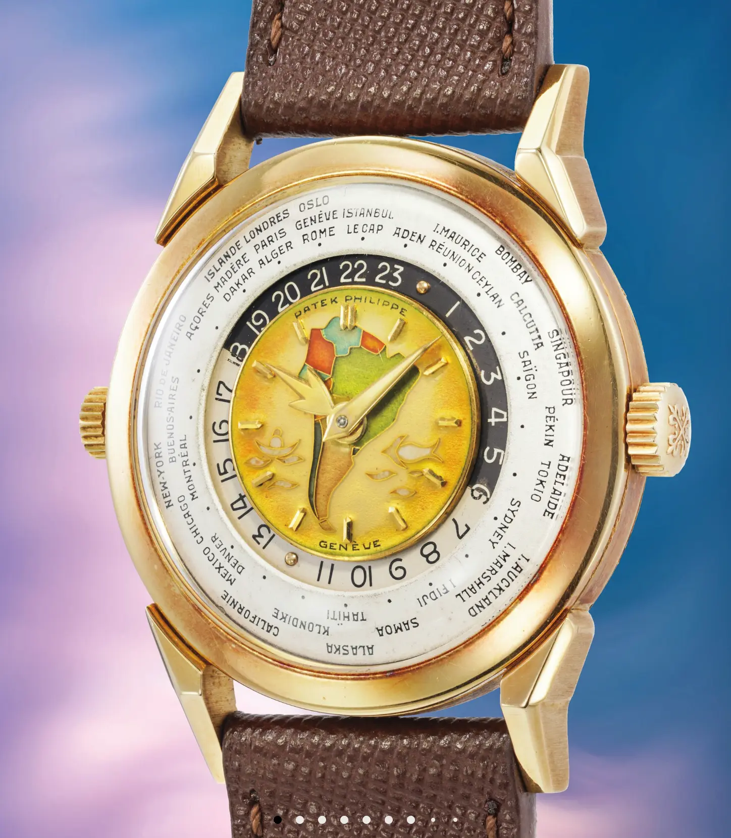 Gold wristwatch with a world-time dial, city names around the bezel, colorful central map, and a brown leather strap.
